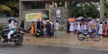 உரிய நேரத்திற்கு அனுமதிக்காததால் மழையில் காத்திருந்த மாணவர்கள்!